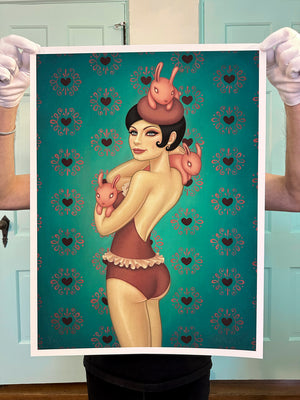 Person holding a poster of a stylized illustration with a woman and rabbits against a patterned background.