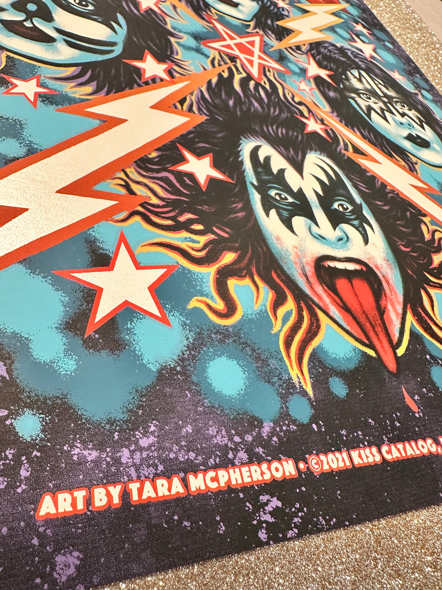 Colorful graphic with a face design, stars, and lightning bolts on a textured surface.