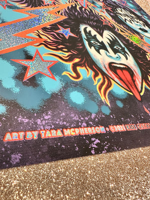 Colorful artwork with a face and star design on a textured surface.